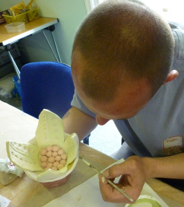 Man painting ceramic flower